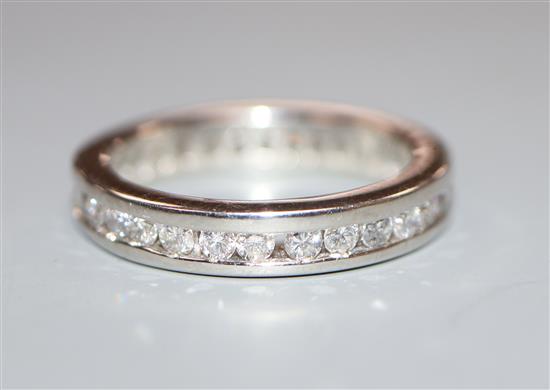 A modern platinum and channel set round brilliant cut diamond set full eternity ring, size M/N.